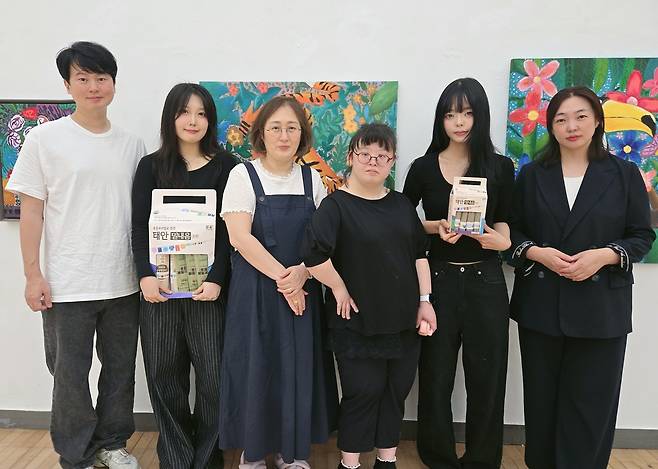 지난 13일 천안 상명갤러리에서 안지혜 디자인이랑 대표(오른쪽 1번째)가 '제3회 너·나·우리 아트마케팅 기획전'에 참여한 이재인 작가(오른쪽 3번째), 정은석 상명대 교수(왼쪽 1번째), 참여 학생 디자이너들과 기념촬영을 하고 있다. 박하늘 기자