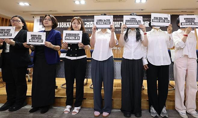 ‘부산 돌려차기 사건’ 등 범죄 피해자들과 변호사들이 지난달 15일 오후 서울 서초구 서울변호사회 변호사회관에서 현재 발의된 형사소송법 개정안의 문제점에 대해 밝히는 기자회견을 하기에 앞서 사진을 찍고 있다. 손팻말로 얼굴을 가린 이들이 피해자들이다. 김정효 기자 hyopd@hani.co.kr