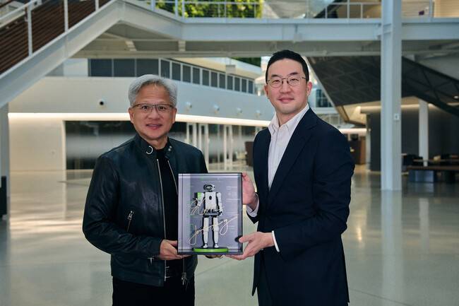 구광모 엘지(LG)그룹 회장과 젠슨 황 엔비디아 최고경영자(CEO)가 지난 13일 미국 캘리포니아주 샌타클래라 엔비디아 본사에서 전략적 사업 협력을 위한 업무협약(MOU)을 맺고 기념사진을 찍고 있다. 가운데 로봇은 엘지가 선물한 휴머노이드 로봇 미니어처로, 젠슨 황의 사인이 담겨 있다. 엘지그룹 제공