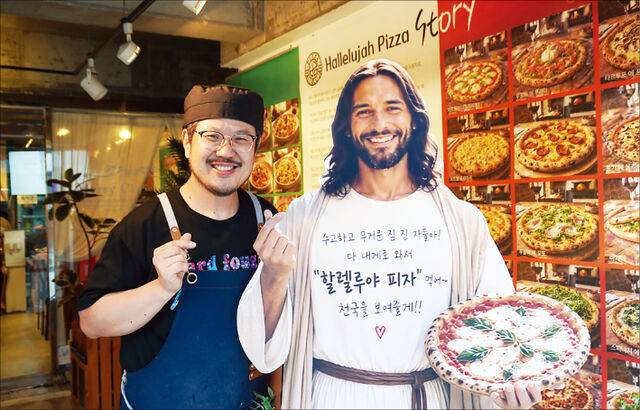 강내우 할렐루야피자 대표가 지난 14일 서울 광진구 군자로 매장에서 예수님 모습 옆에 서 있다.