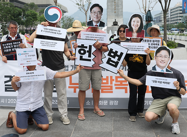 지난달 16일 서울 광화문광장에서 기후위기비상행동이 연 ‘헌재결정 이행과 탄소중립법 개정을 위한 제헌절 기자회견’에서 참가자들이 온실가스감축목표를 법률로 마련할 것을 촉구하는 퍼포먼스를 하고 있다. [연합]