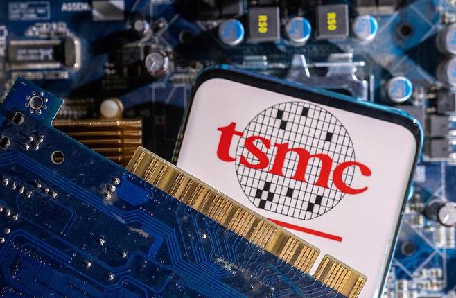 세계 최대 파운드리 기업 TSMC 로고가 표시된 스마트폰이 PC 메인보드 위에 올려져 있다. 로이터 연합뉴스