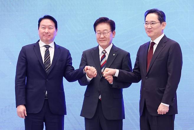 이재명 대통령과 이재용 삼성전자 회장, 최태원 SK그룹 회장이 6월 29일 청와대 영빈관에서 열린 '대한민국 대도약 3대 메가프로젝트' 국민보고회에서 손을 맞잡고 있다. 뉴스1