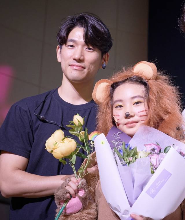 어린이 뮤지컬 극단 ‘올뮤지컬’의 이준일(왼쪽) 단장이 2023년 9월 ‘오즈의마법사’ 공연에 출연한 어린이 단원과 기념촬영을 하고 있다.  초록우산 제공