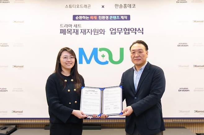 스튜디오 드래곤의 사업지원팀장 이혜미(왼쪽)와 한솔홈데코의 지원혁신팀장 양병갑이 지난 1월 15일 사업협약 체결 후 기념사진을 촬영하고 있다. [한솔홈데코]