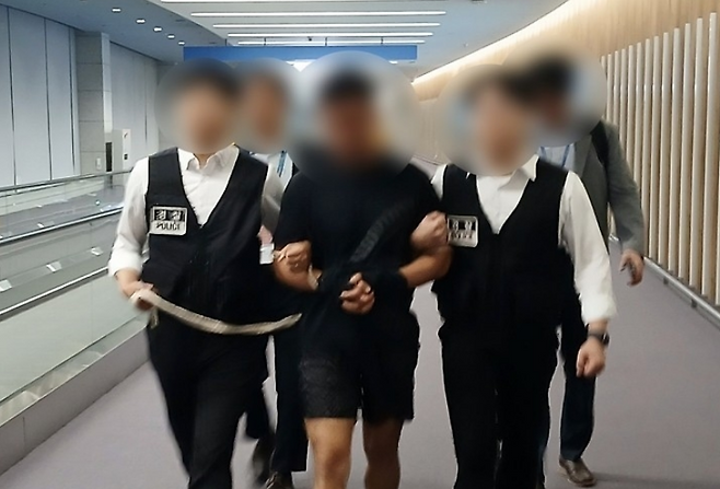 법무부 관계자들이 22일 그룹 방탄소년단(BTS) 정국을 포함한 국내 재력가들의 명의를 도용해 거액을 빼돌린 해킹조직 총책급 범죄인인 중국 국적 전모씨를 인천국제공항을 통해 강제송환하고 있다. 법무부 제공