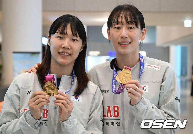 [OSEN=인천공항, 조은정 기자]2026 세계배드민턴연맹(BWF) 세계선수권대회를 마친 대한민국 배드민턴 대표팀이 25일 인천국제공항을 통해 귀국했다.대표팀은 세계선수권대회에서 금메달 2개와 동메달 1개를 수확하며 종합 1위에 올랐다. 여자 복식에서 금메달을 따낸 이소희(오른쪽)와 백하나가 금메달을 들고 포즈를 취하고 있다. 2026.08.25 /cej@osen.co.kr