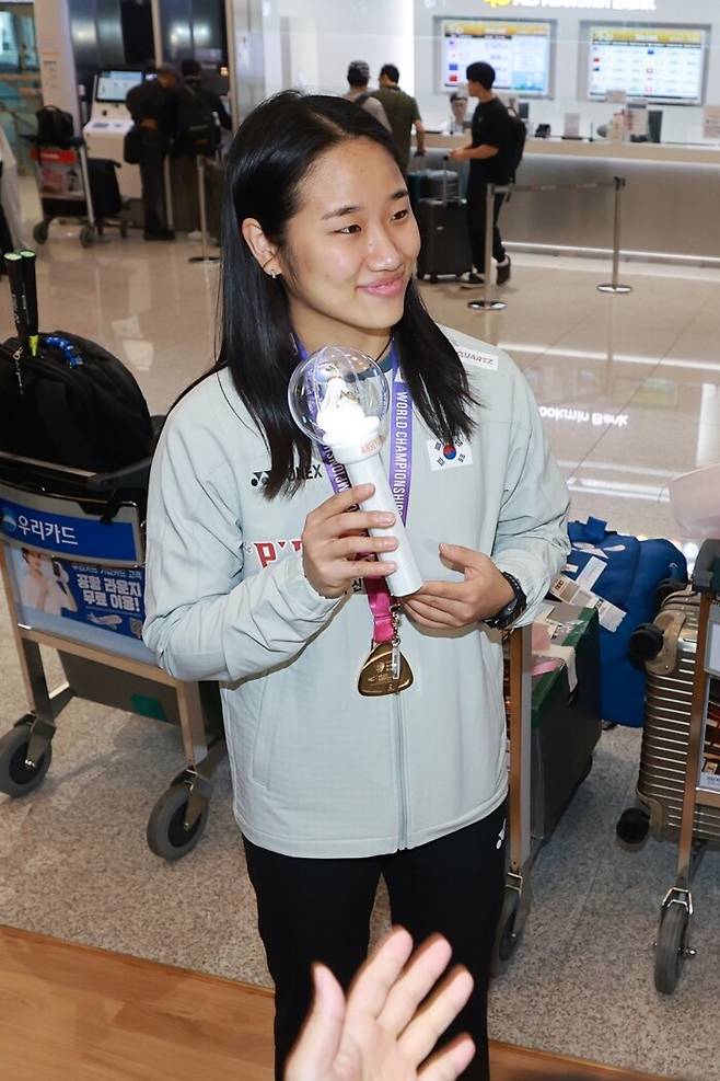 ▲ 2026 세계배드민턴연맹(BWF) 세계선수권대회 여자 단식에서 우승한 안세영이 25일 인천국제공항 제2여객터미널을 통해 귀국한 뒤 팬들이 선물한 응원봉을 들어보이고 있다.ⓒ연합뉴스