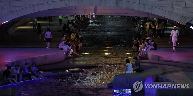 서울 열대야 (서울=연합뉴스) 류영석 기자 = 기상청이 서울 동남·동북·서북권에 열대야주의보를 발효한 지난 24일 밤 서울 청계천을 찾은 시민들이 물에 발을 담그고 있다. 2026.8.24 ondol@yna.co.kr