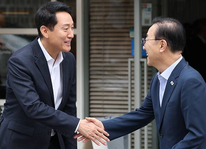 김윤덕 국토교통부 장관(오른쪽)과 오세훈 서울시장이 26일 서울 모처의 한 식당에서 용산공원을 활용한 주택 공급 등 서울 주택 문제를 협의한 뒤 나서며 악수하고 있다. [연합]