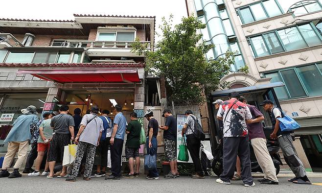 주민들이 19일 서울 관악구 대학동에서 시민단체 길벗사랑공동체 ‘해피인’이 점심에 무료로 나눠 주는 도시락을 받기 위해 줄을 서 있다. 남정탁 기자