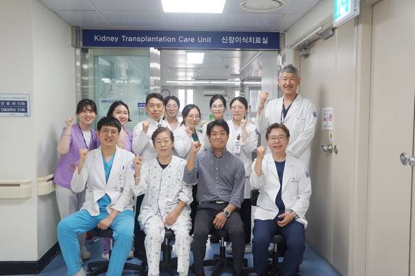 지난 11일 부산 봉생기념병원에서 신장이식 수술을 받은 엄마(앞줄 왼쪽 두 번째)와 아들(앞줄 왼쪽 세 번째)이 퇴원을 앞두고 신장이식팀과 함께 기념촬영을 하고 있다.  봉생기념병원 제공