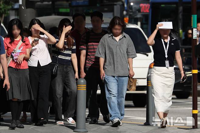 [서울=뉴시스] 김명년 기자 = 사진은 지난달 29일 서울 중구 세종대로 사거리에서 시민들이 손으로 햇볕을 가리며 이동하고 있는 모습. 2026.07.29. kmn@newsis.com