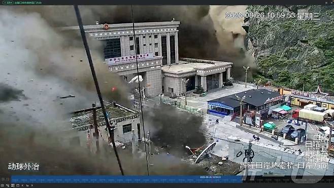 26일 중국 티베트 지롱 지역의 네팔·중국 국경지대 계곡에서 진흙과 물의 벽이 건물을 휩쓸어 파괴하자 사람들이 달아나는 모습. 소셜미디어 영상에서 확보한 CCTV 화면 캡처. 2026.08.26 ⓒ 로이터=뉴스1