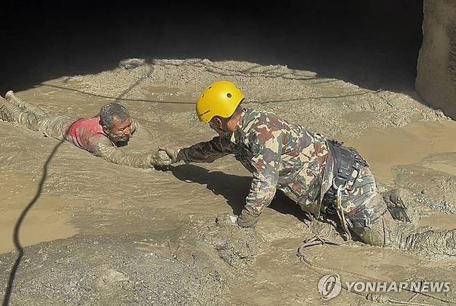 터널 내 진흙탕 속 생존자 구조 지난 28일(현지시간) 네팔 중부 바그마티주 라수와의 한 수력발전소 터널에서 네팔군 구조대가 생존자를 구출하고 있다. [EPA 연합뉴스 자료사진. 재판매 및 DB 금지]