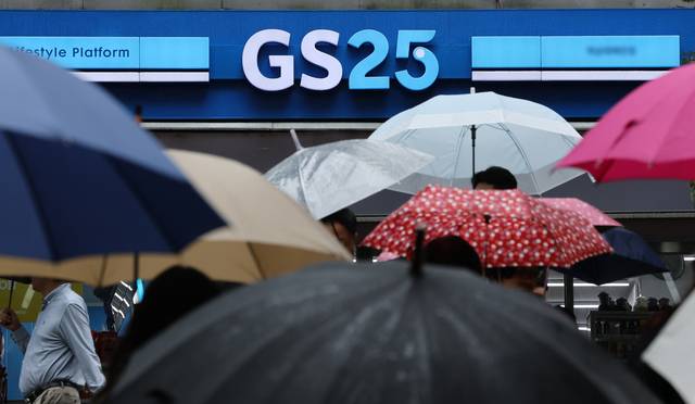서울 한 GS25 편의점 앞에 우산 쓴 시민들이 걸어가고 있다. 연합뉴스