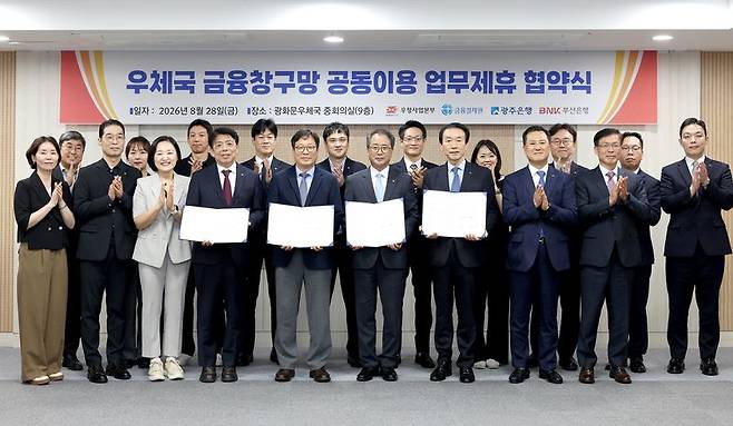 광주은행 정일선 은행장(앞줄 왼쪽 네번째부터), 우정사업본부 박인환 본부장, 금융결제원 채병득 원장, BNK부산은행 김성주 은행장이 업무협약서를 들고 포즈를 취하고 있다. 부산은행 제공