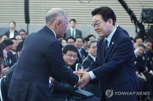 이재명 대통령이 지난 2월 27일 전북 군산새만금컨벤션센터에서 개최된 새만금 로봇·수소·AI 시티 투자협약식에서 정의선 현대차그룹 회장과 악수하고 있다. 연합뉴스