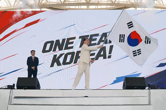 이상현 2026 아이치·나고야 아시안게임 선수단장이 3일 충북 진천선수촌에서 열린 결단식에서 유승민 대한체육회장으로부터 단기를 받아 흔들고 있다. 진천=연합뉴스