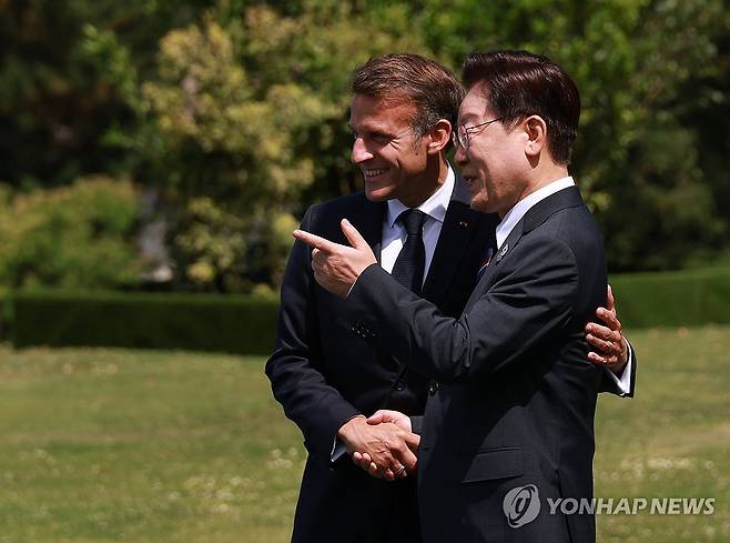 이재명 대통령, G7 환영식 참석 (에비앙=연합뉴스) 한상균 기자 = 이재명 대통령이 16일(현지시간) 프랑스 에비앙레뱅 주요 7개국(G7) 정상회의 행사장에서 열린 초청국 환영행사에서 의장국인 프랑스의 에마뉘엘 마크롱 대통령과 대화하고 있다. 2026.6.16 xyz@yna.co.kr