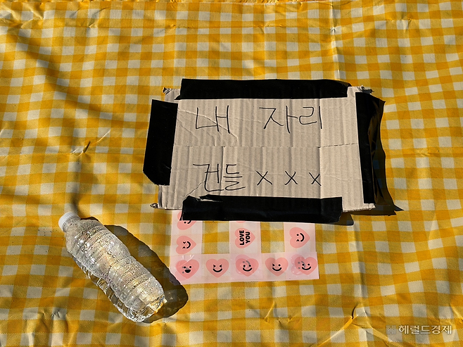 4일 오전 서울 영등포구 여의도 한강공원 잔디밭에 고정돼 있던 돗자리. 사람 없는 돗자리 위에 ‘내 자리 건들XXX’ 이라는 문구가 붙어있다. 전새날 기자