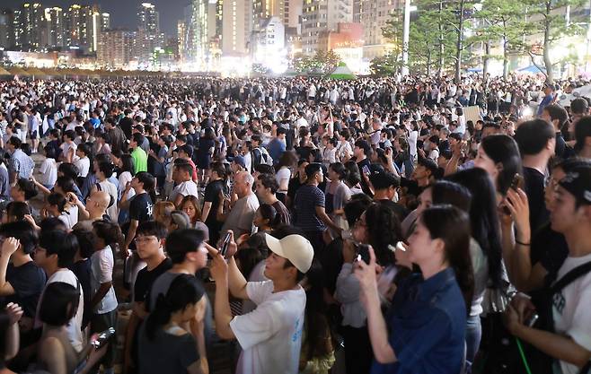 부산 수영구 광안리해수욕장에서 시민과 관광객들이 '광안리 M 드론 라이트쇼'를 관람하고 있다. 사진 연합뉴스