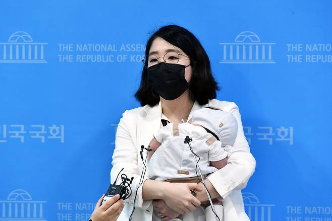 용혜인 기본소득당 의원이 2021년 7월5일 국회 소통관에서 기자회견을 마친 후 아기를 안은 채 취재진의 질문에 답하고 있다. 국민일보DB