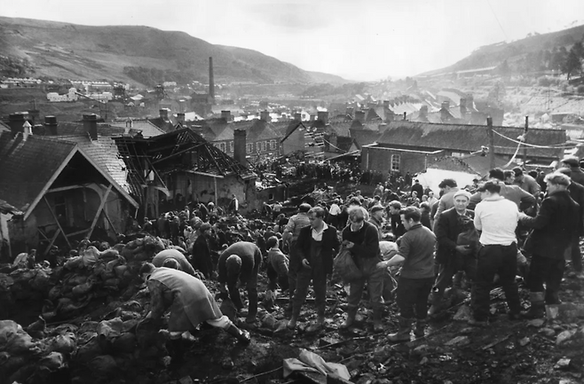 1966년 폐석탄 더미 산사태 직후의 영국 웨일스 한 탄광마을(Aberfan) 피해 현장. 석탄과 진흙더미가 마을과 초등학교를 덮쳐 어린이 109명을 포함한 144명이 숨진 저 참극의 원인은 탄광 폐기물 관리 및 안전 수칙 미비였지만, 영국 아동복지와 안전시스템의 공백을 보여준 상징적 사례이기도 했다. 레밍 경이 청년 보호관찰관으로 공무원 생활을 갓 시작하던 1960년대 영국 탄광마을의 실정이 대체로 그러했다. 게티 이미지