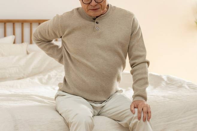 등 통증을 호소하는 모습. 췌장암은 윗배 통증이 등으로 번지거나 누웠을 때 심해지고, 몸을 앞으로 숙이면 완화되는 양상으로 나타날 수 있다. 클립아트코리아