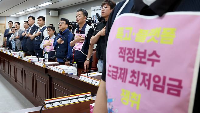 정부가 개인 사업자인 보험설계사, 배달기사 등을 근로자로 간주하는 ‘근로자 추정제’ 입법화를 추진하고 있다. 사진은 지난달 최저임금위원회 회의 시작 전 ‘노동계 추천’ 근로자위원이 ‘특고(특수형태근로종사자)·플랫폼 (노동자) 적정 보수’ 등의 문구가 적힌 조끼를 입고 국민의례를 하는 모습이다.민의례를 하고 있다. /뉴스1