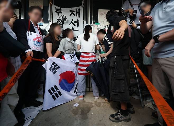 6·3 지방선거 투표용지 부족 사태로 시작한 서울 송파구 올림픽공원 핸드볼경기장 일대 '개표소 봉쇄 시위'가 이어진 지난 6월16일 '올다르크(올림픽공원 잔다르크)' 라고 불리는 한 시위 참가자가 문을 가로막아 체육단체 직원들이 경기장 안으로 들어가지 못하고 있다. ⓒ연합뉴스