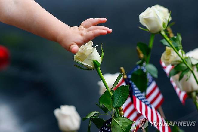 25th ANNIVERSARY 9/11 A child touches a flower next to the reflecting pools during a remembrance ceremony marking the 25th anniversary of the 9/11 attacks at the National September 11 Memorial & Museum at Ground Zero in New York on Friday, September 11, 2026.  A total of 2,753 people died in the attack on the World Trade Center on September 11, 2001.    Pool Photo by Jeenah Moon/UPI
