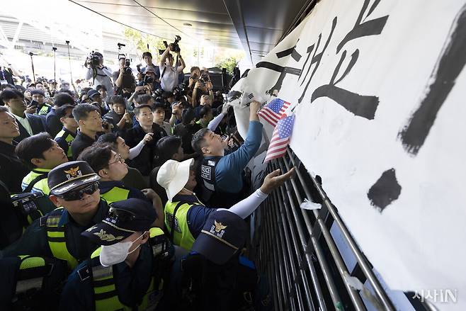 6·3 지방선거 투표용지 부족 사태로 촉발된 잠실 개표소 봉쇄 시위가 이어지는 9월8일 오전, 서울 올림픽공원 핸드볼경기장을 찾은 경찰이 ‘당일투표 수개표’ 등의 문구를 떼고 있다. ⓒ시사IN 이명익