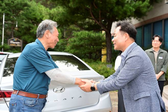 김학홍 문경시장이 고유가 민생지원금 신청 접수 현장에서 시민과 함께 손을 잡고 환하게 인사를 나누고 있다./사진제공=경북 문경시