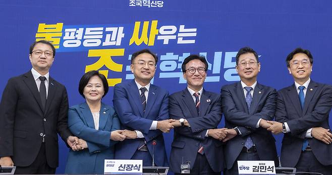 김민석 더불어민주당 대표(왼쪽 네 번째)가 지난달 24일 취임 인사를 하기 위해 조국혁신당을 방문해 신장식 대표(왼쪽 세 번째)를 비롯한 참석자들과 손을 맞잡고 기념 촬영하고 있다. (왼쪽부터) 조국혁신당 박병언 대변인, 정춘생 사무총장, 신 대표, 민주당 김 대표, 김태선 당대표 비서실장, 이용우 대변인. 연합뉴스