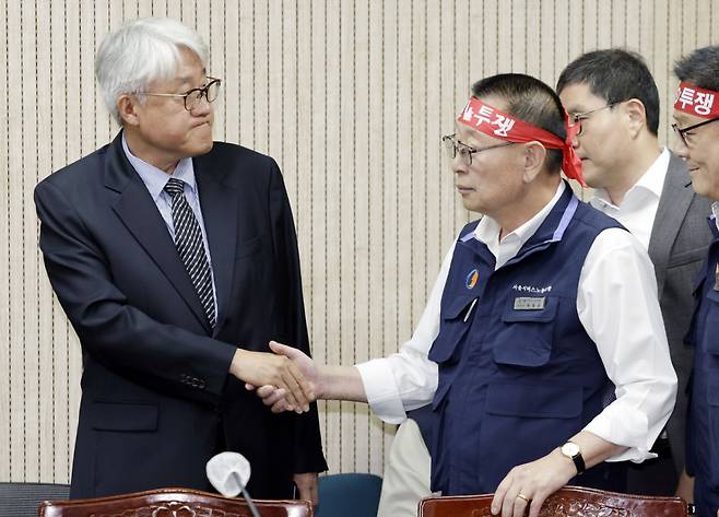 김정환(왼쪽) 서울시버스운송사업조합 이사장과 박점곤 전국자동차노동조합연맹 서울시버스노동조합 위원장이 지난 15일 서울 영등포구 서울지방노동위원회에서 열린 서울시내버스 노사 2차조정회의에서 악수하고 있다./사진=뉴시스