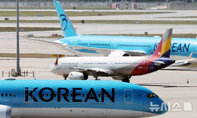 [인천공항=뉴시스] 박주성 기자 = 아시아나항공이 임시주주총회를 열고 대한항공과 합병 체결을 가결한 12일 인천국제공항 제2여객터미널 활주로에 대한항공과 아시아나 항공기가 이동하고 있다. 2026.08.12. park7691@newsis.com