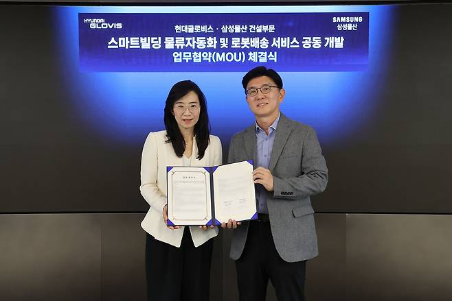 한규헌 현대글로비스 미래혁신기술센터장(오른쪽)과 조혜정 삼성물산 DxP본부장이 16일 서울 성동구 현대글로비스 본사에서 ‘스마트빌딩 물류자동화 및 로봇배송 서비스 공동 개발’을 위한 업무협약(MOU)을 체결한 뒤 기념촬영을 하고 있다. [현대글로비스 제공]