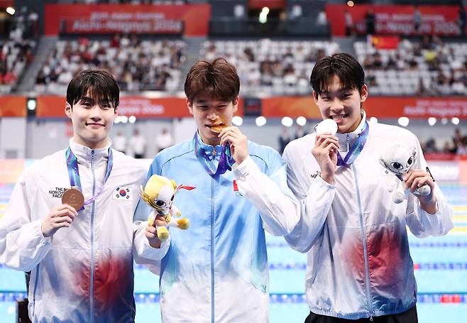김 20일 도쿄 아쿠아틱스 센터에서 열린 2026 아이치·나고야 아시안게임 수영 남자 100m 자유형 결승에서 은메달과 동메달을 획득한 한국 김영범, 황선우가 기념촬영하고 있다. 가운데는 금메달을 차지한 중국 판잔러. <저작권자(c) 연합뉴스, 무단 전재-재배포, AI 학습 및 활용 금지>
