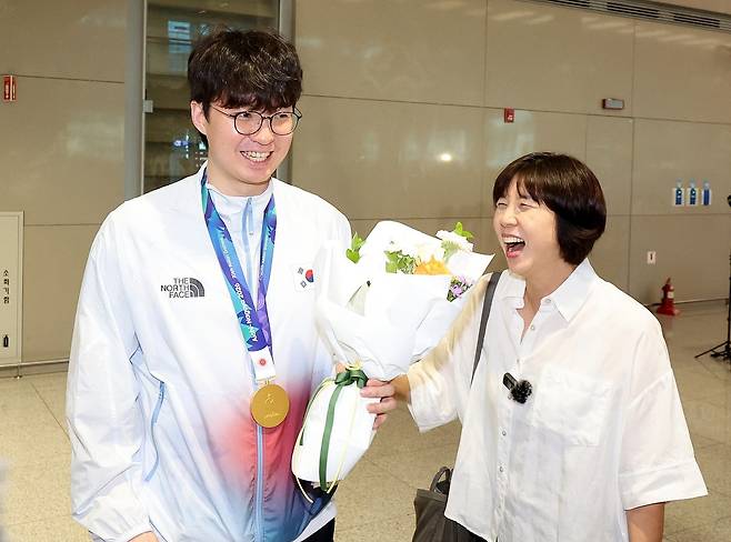 2026 나고야 아시안게임에서 금메달을 차지한 대한민국 농구대표팀 이현중이 21일 인천국제공항 제2여객터미널을 통해 귀국해 어머니 성정아 대한농구협회 이사와 함께 미소 짓고 있다. 2026.9.21/뉴스1
