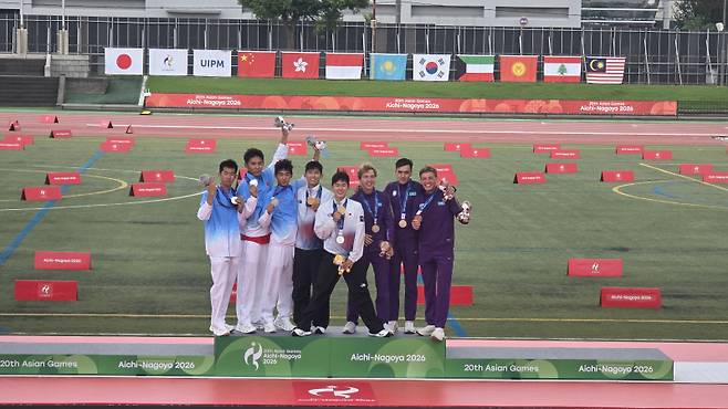 ▲ 한국 근대5종 국가대표팀 전웅태와 이종현이 20일 일본 아이치 안조 스포츠 파크에서 열린 2026 아이치-나고야 아시안게임 근대5종 남자 단체전에서 금메달을 획득한 뒤 시상대에 올라 기뻐하고 있다.  한규빈 기자