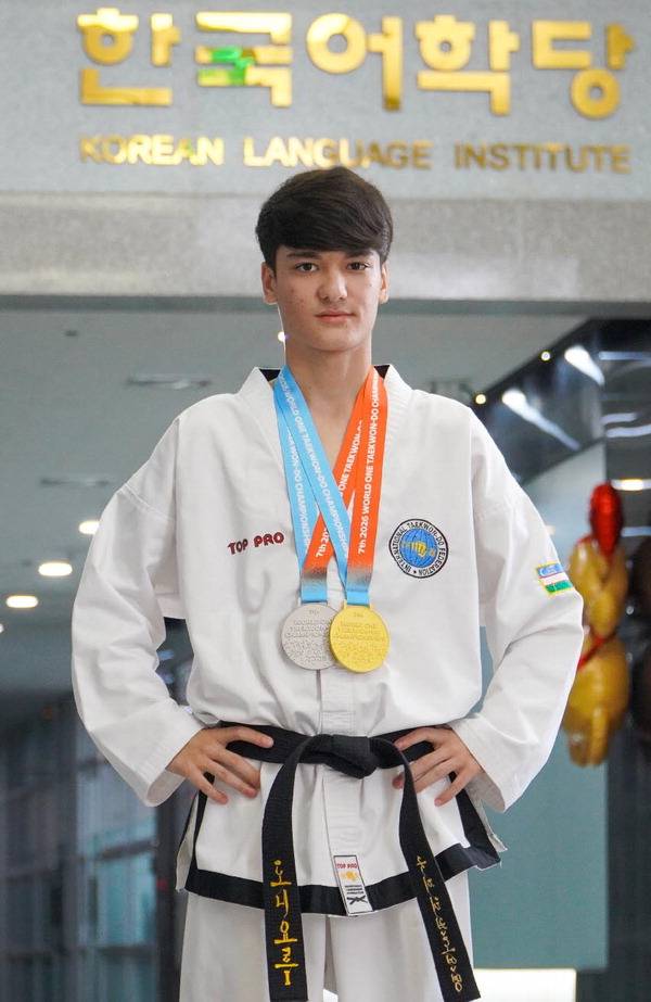 19살 우즈베키스탄 청년인 압둘라예프 군이 태권도 국제대회에서 딴 메달을 목에 걸고 자신이 공부하고 있는 경남정보대 한국어학당 앞에서 포즈를 취했다. 경남정보대 제공