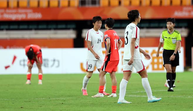 21일 일본 시즈오카현 후쿠로이의 시즈오카 스타디움 에코파에서 열린 2026 아이치·나고야 아시안게임 여자 축구 조별리그 대한민국과 북한의 경기. 1-1로 경기를 마친 양팀 선수들이 아쉬워하고 있다.[연합뉴스]