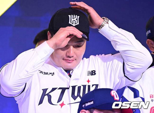 [OSEN=최규한 기자] 21일 오후 서울 잠실동 롯데호텔 월드 크리스탈볼룸에서 ‘2027 KBO 신인드래프트’가 열렸다.&nbsp;이번 신인드래프트는 2025시즌 순위의 역순에 따라 키움 히어로즈, 두산 베어스, KIA 타이거즈, 롯데 자이언츠, KT 위즈, NC 다이노스, 삼성 라이온즈, SSG 랜더스, 한화 이글스, LG 트윈스 순서로 1라운드부터 11라운드까지 지명할 수 있다.&nbsp;최지만이 전제 15순위로 KT 위즈에 지명된 뒤 기념촬영을 준비하고 있다. 2026.09.21 / dreamer@osen.co.kr