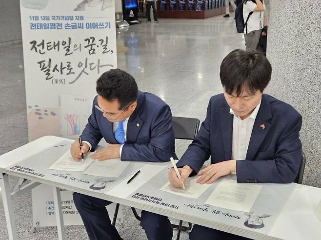 민병덕 더불어민주당 의원(왼쪽)과 한창민 사회민주당 대표가 22일 전태일 평전 손글씨 이어쓰기'에 참여하고 있다. 전태일재단 제공