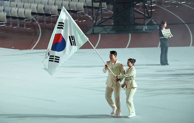 19일 일본 나고야 미즈호공원 육상경기장에서 열린 2026 아이치·나고야 아시안게임 개회식에서 한국 선수단 기수로 선정된 조정 김동용과 탁구 신유빈(오른쪽)이 태극기를 들고 입장하고 있다. 연합뉴스