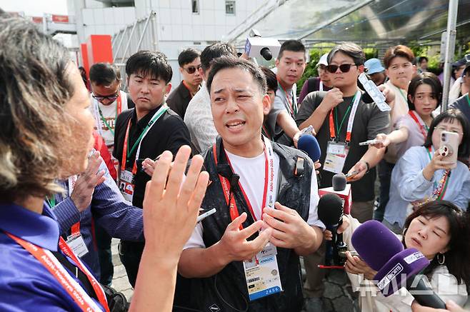 [나고야=뉴시스] 황준선 기자 = 18일 오후 일본 나고야향 인근에 마련된 2026 아이치·나고야 아시안게임 선수촌에서 열린 입촌식에서 행사가 지연되자 대회 조직위 관계자가 취재진에게 사과하고 있다. 이날 행사는 약 90분간 지연됐다. 2026.09.18. hwang@newsis.com