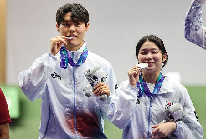 대한민국 홍수현과 추가은이 25일 일본 도요타시 아이치현 종합사격장에서 열린 2026 아이치·나고야 아시안게임 사격 혼성 단체 10m 공기권총 결선 시상식에서 은메달을 들고 기념촬영을 하고 있다. 뉴스1