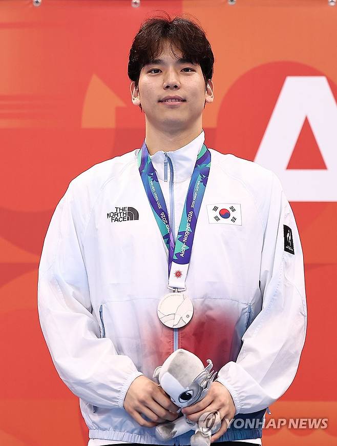 은메달 목에 건 이주호 (도쿄=연합뉴스) 윤동진 기자 = 25일 도쿄 아쿠아틱스 센터에서 열린 2026 아이치·나고야 아시안게임 수영 남자 200m 배영에서 은메달을 획득한 한국 이주호가 메달을 목에 걸고 있다. 2026.9.25 mon@yna.co.kr