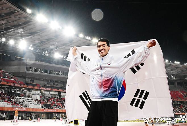 27일 일본 나고야 미즈호공원 육상경기장에서 열린 '2026 아이치·나고야 아시안게임' 남자 높이뛰기 결선에 출전한 대한민국 우상혁이 2m22를 기록하며 전체 14명 중 최종 3위로 동메달을 획득했다.   경기 종료 후 우상혁이 태극기를 들고 환히 웃고 있다. 일본 나고야, 박지영 기자